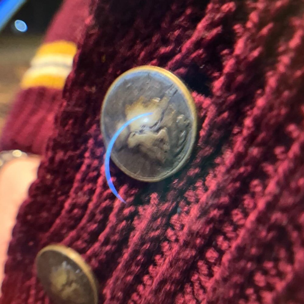 Detail of a MerCureY cardigan button
